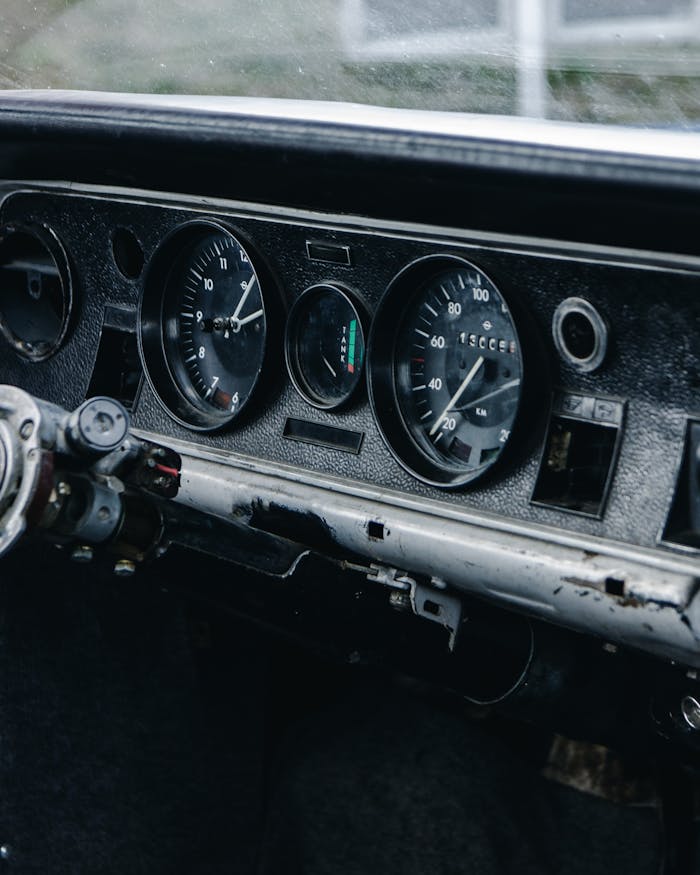 Close-up of a vintage car dashboard featuring a classic speedometer and gauges.